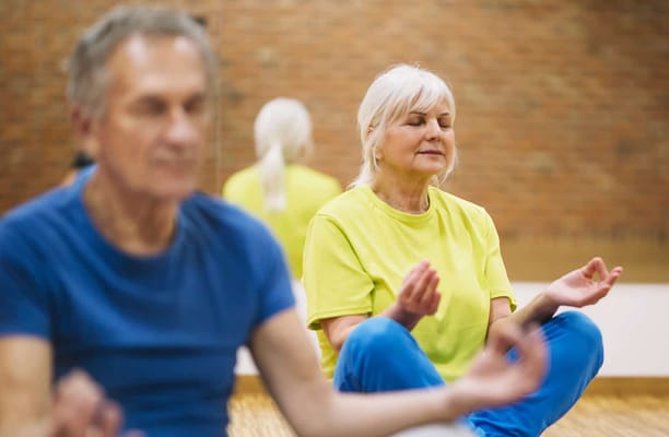 Residents participating in a yoga activity indoors
