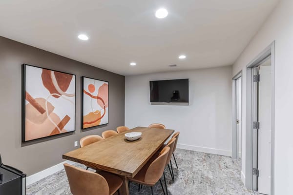 Bright common area with large table and artwork