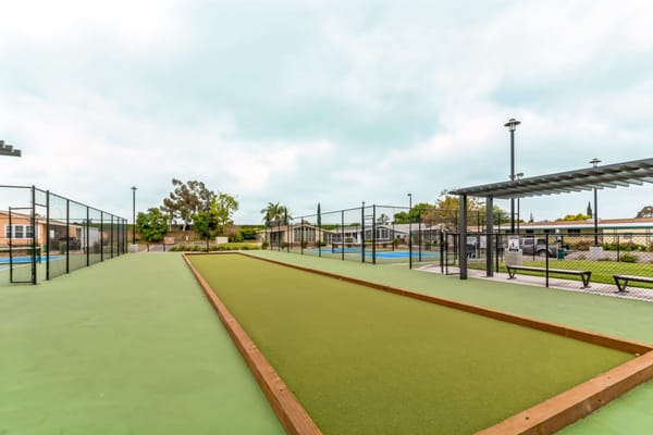 Outdoor bowling green area with seating and landscape