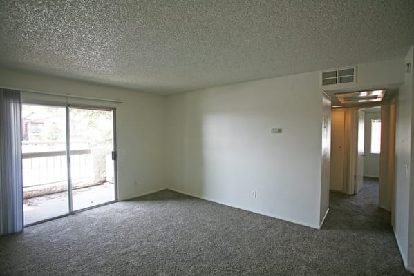 Empty living room with sliding glass door to balcony