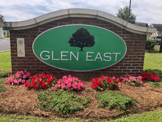 Sign of Glen East Senior Apartments with colorful flowers