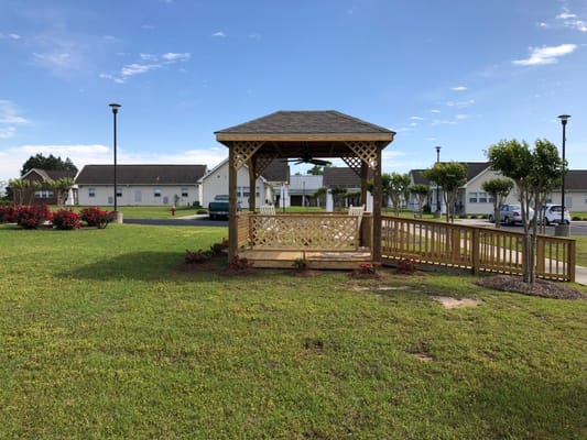Wooden gazebo surrounded by greenery