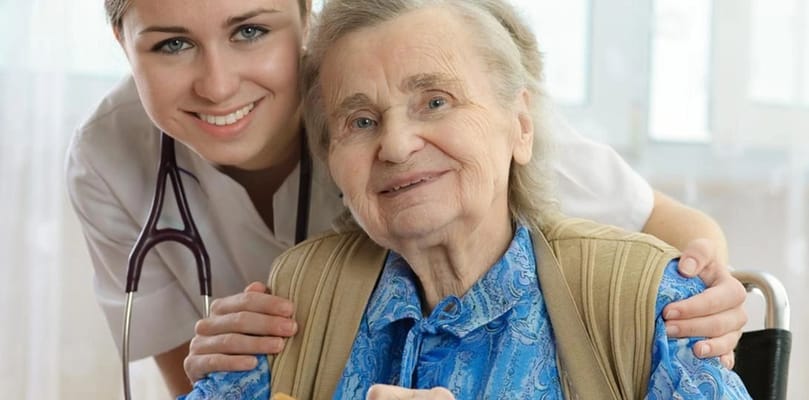 A caregiver smiling with an elderly resident