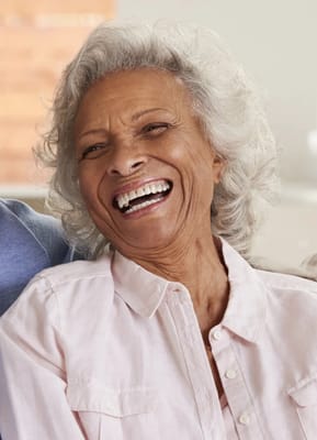 Senior woman smiling brightly in a bright room