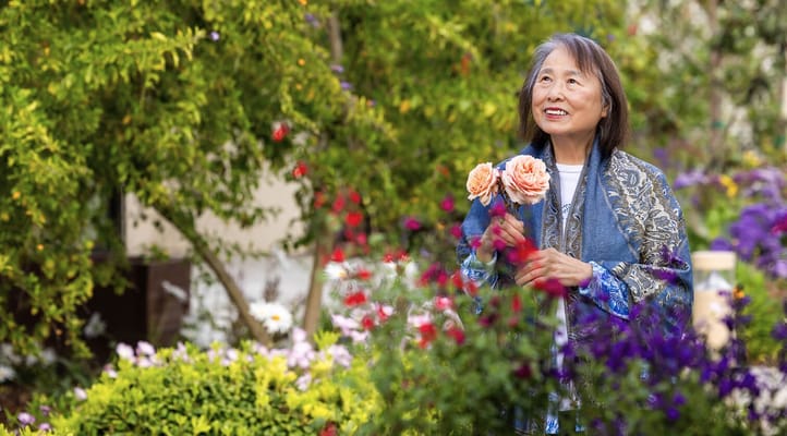 Senior woman enjoying flowers in a garden