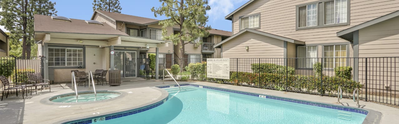 Outdoor pool area with seating and greenery