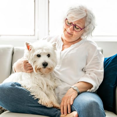 Senior woman with a dog in a cozy indoor setting