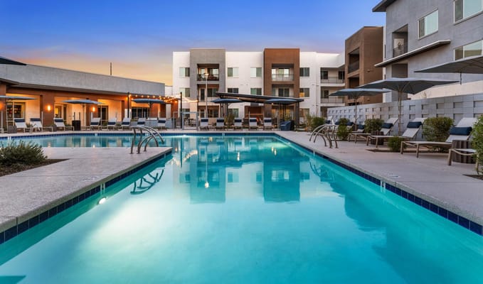 Outdoor pool area with lounge chairs and umbrellas