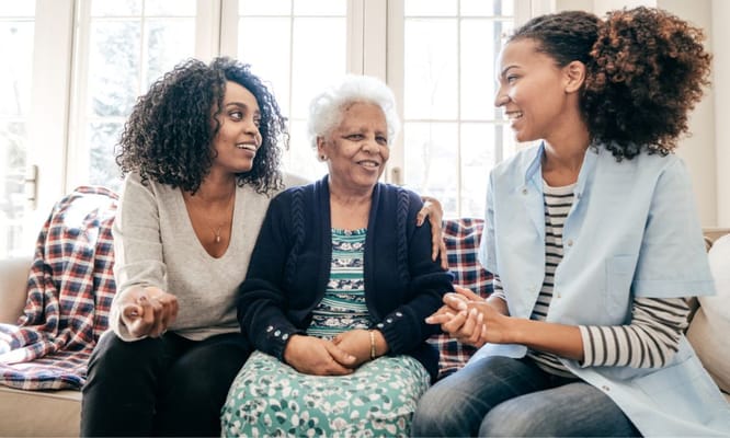 Three women chatting in a cozy common area