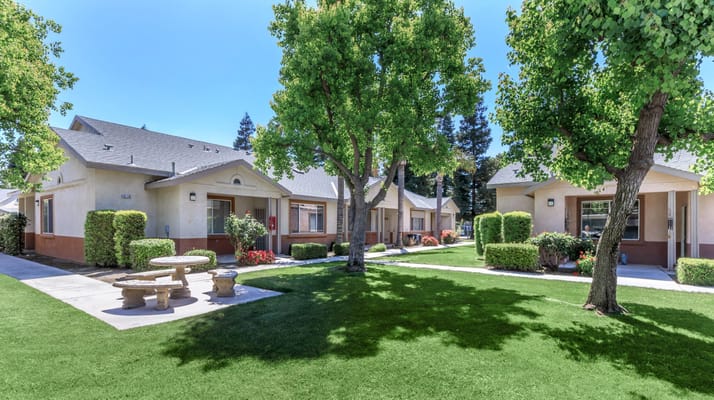 Outdoor view of Brookside Senior Apartments with green lawn and trees