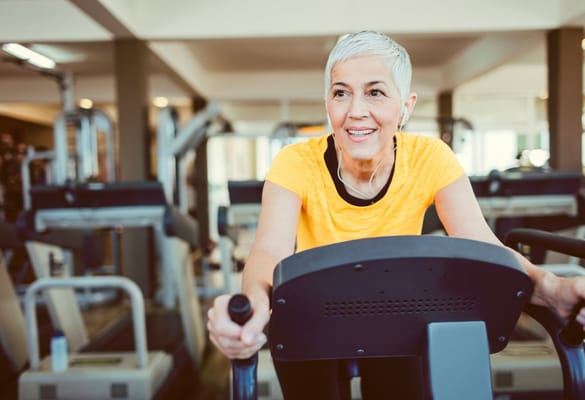 Senior woman exercising on a stationary bike