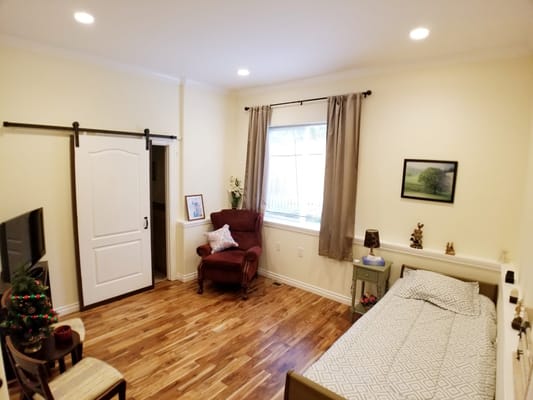 Interior view of a senior living room with a bed and seating area.