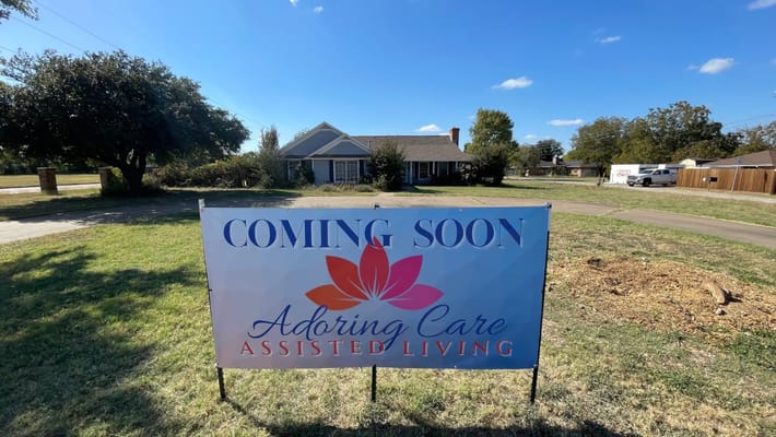 Outdoor banner announcing Adoring Care Assisted Living