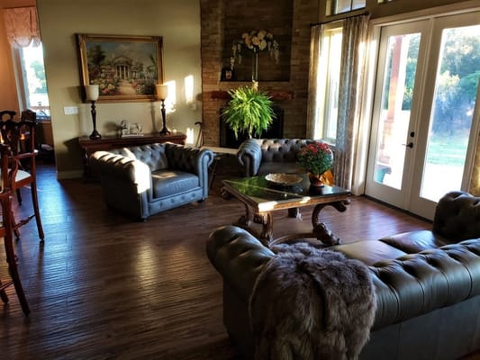 A cozy living room with leather sofas, a coffee table, and large windows