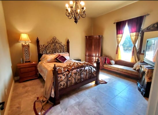Spacious bedroom with a queen bed and decorative furnishings.