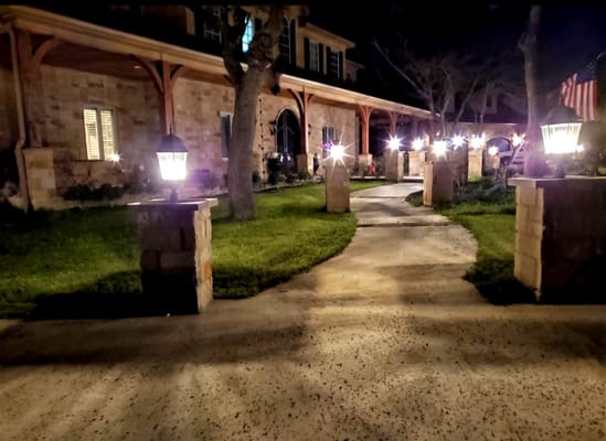 A beautifully lit pathway lined with lanterns leading to Starwood Manor, Cedar Park, TX.
