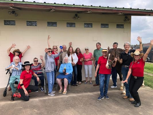Group of seniors and staff smiling and posing with a horse