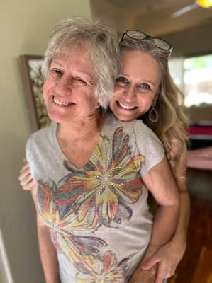 Two women smiling together, indoor setting