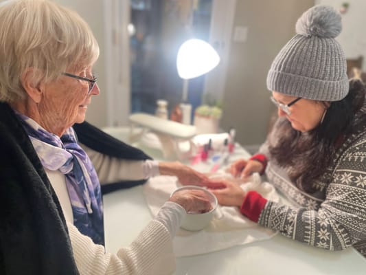Resident enjoying a manicure with staff assistance