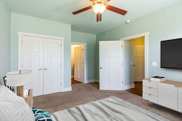 Spacious bedroom with a ceiling fan and modern furnishings