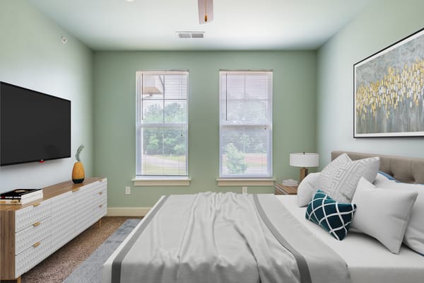Comfortable bedroom with a bed, dresser, and large TV