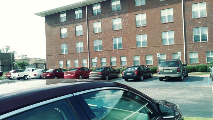 View of the parking lot at Villa Maria Apartments with multiple cars parked.
