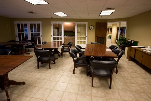 A spacious common area with tables and chairs at Baptist Oaks Apartments.