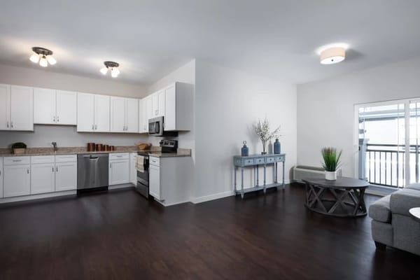 Spacious living room and kitchen area in Monark Grove apartment.