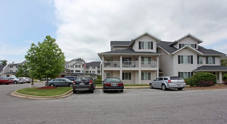 Exterior view of the Rocky Ridge Retirement Community building with parked cars.