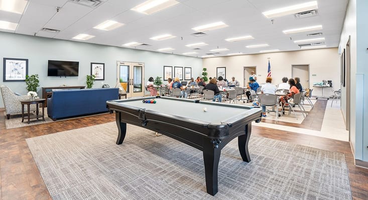 Activity room with billiards table and residents engaged in group activities