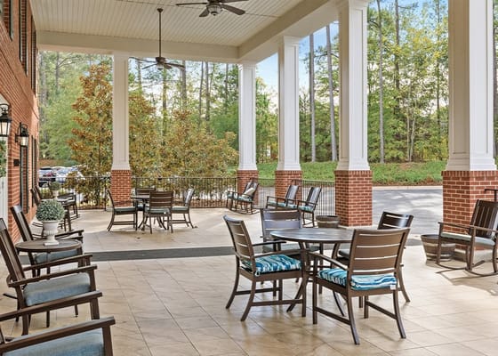 Outdoor patio area with chairs and tables at Summer Village Magnolia Place