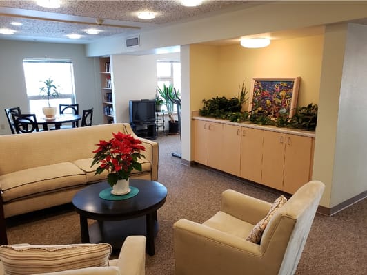 Comfortable seating area with a table, plants, and artwork