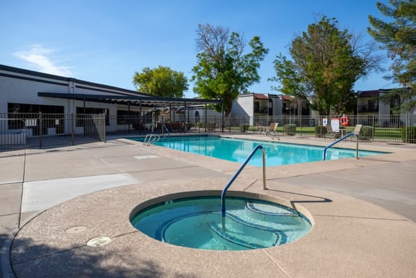 Outdoor pool area with spa and seating