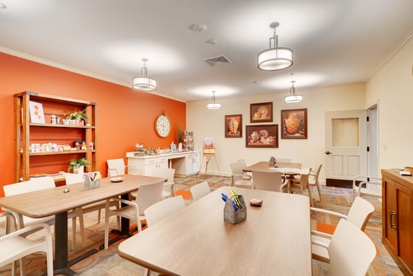 Bright and inviting common room with tables and artwork