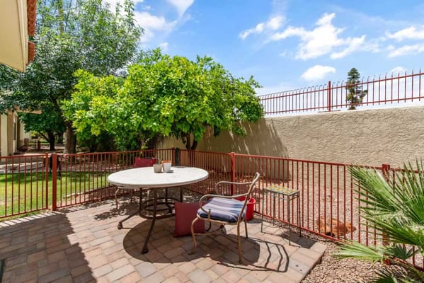 Outdoor patio area with table and greenery