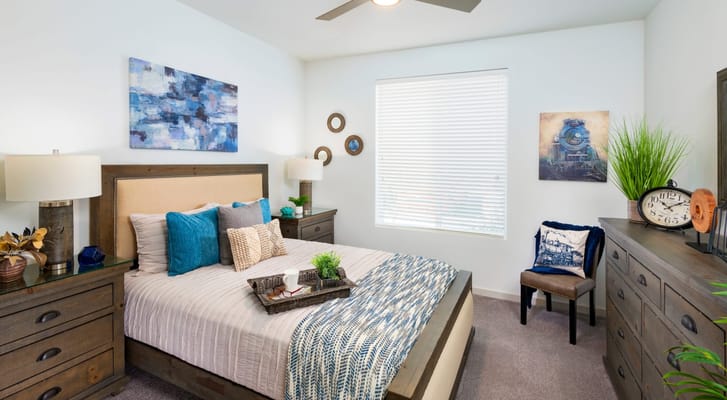 Brightly decorated bedroom with a bed, nightstand, and artwork.
