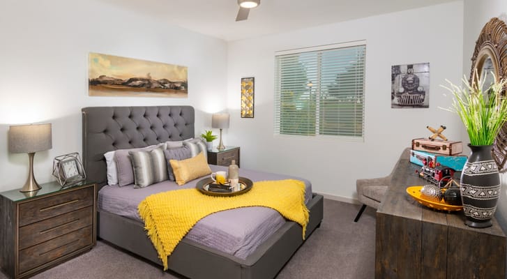 Cozy bedroom featuring a gray bed, decorative pillows, and bedside tables.