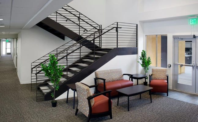 Interior view of a lobby with a staircase and seating area