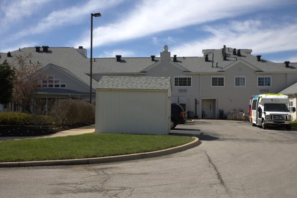 Exterior view of a nursing home with landscaping and a van.