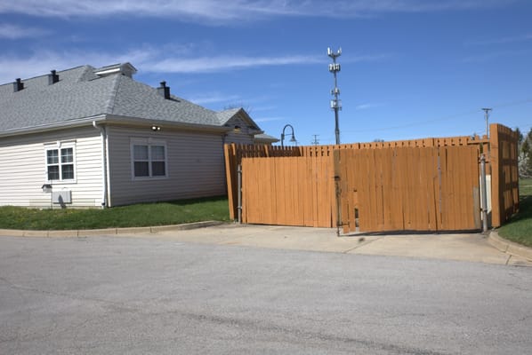 Exterior view of a single-story building with a wood fence