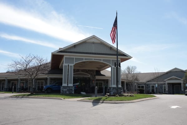 Front entrance of a senior living facility with flag