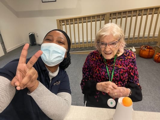 A staff member and a resident smiling together indoors