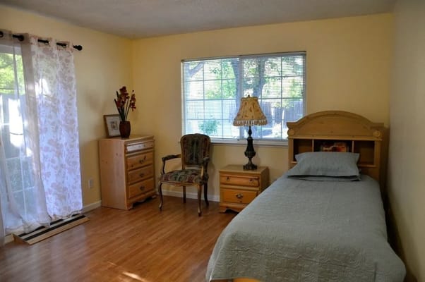 Brightly lit private resident room with simple furnishings