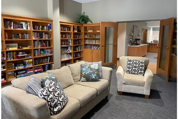Bright common area with a couch and bookshelves