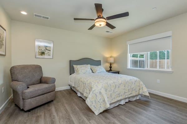 Cozy private resident room with a bed and chair