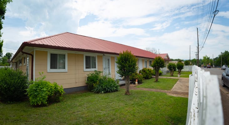 Exterior view of Davis Retirement Home with greenery and red roof.