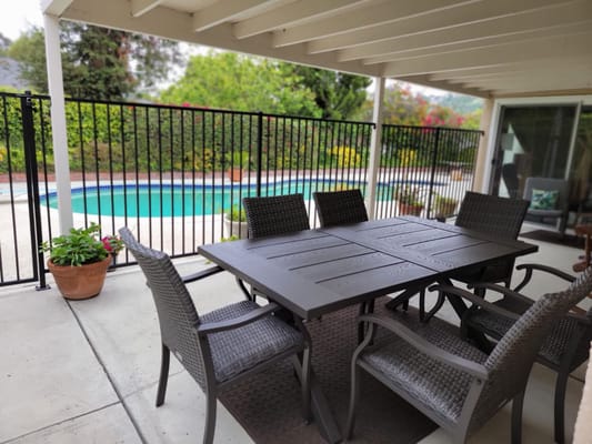 Outdoor patio with a pool view and seating