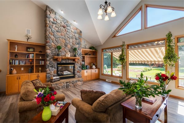 Inviting living room with stone fireplace and large windows