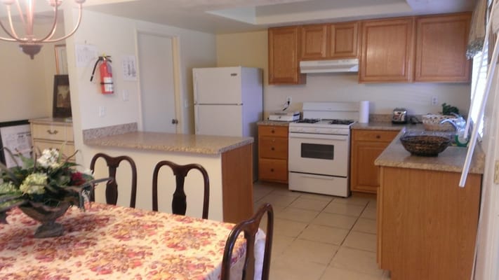Interior view of the kitchen and dining area with wooden cabinets and a table