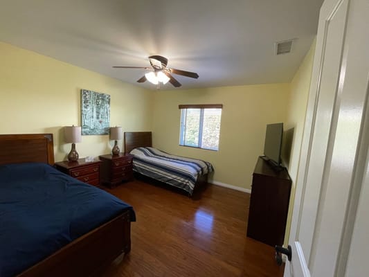 A private resident room with two beds and natural light
